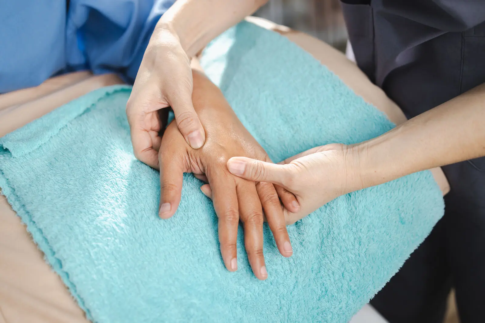 Physiotherapist examining a patient's hand and wrist