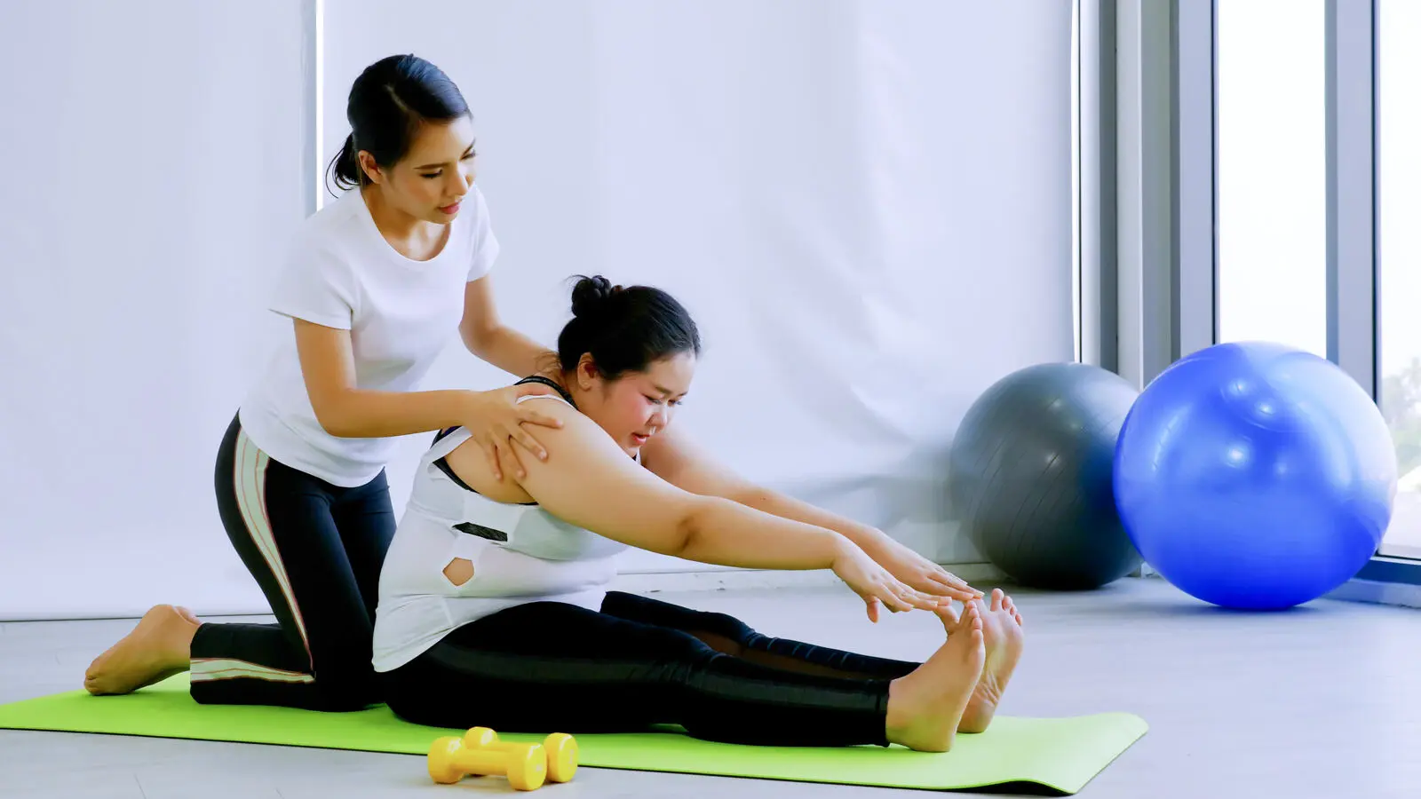 Person managing lower back pain with a supported rehabilitation exercise
