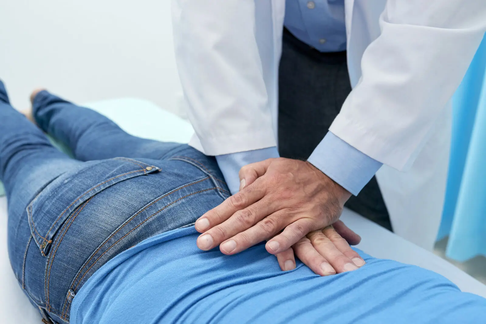 Physiotherapist assessing a patient's lower back